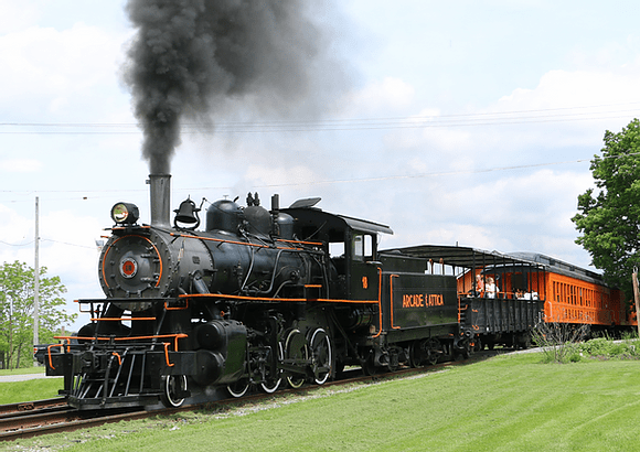 a steam engine on a train track with smoke coming out of it